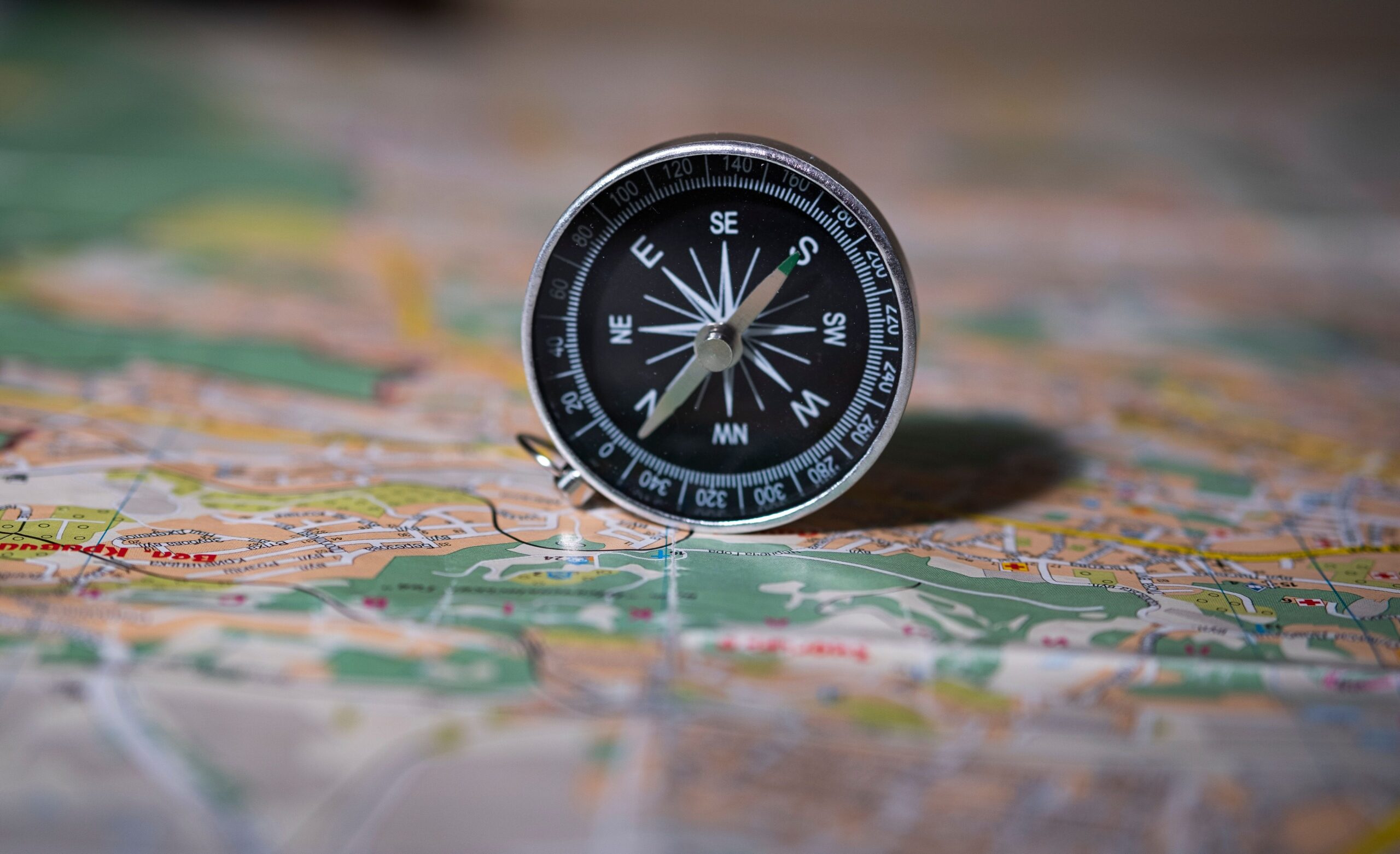 Black compass on detailed map symbolizing navigation and exploration.